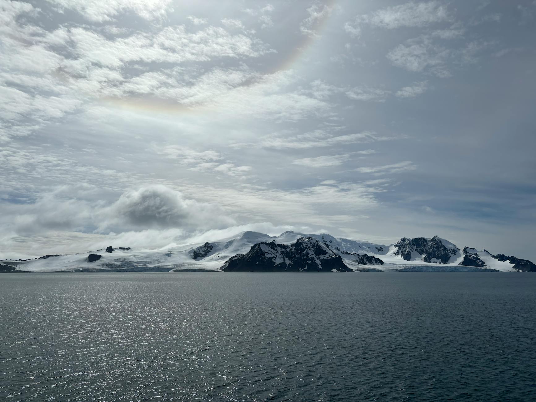 Lodowce Antarktydy nad spokojnym oceanem pod zachmurzonym niebem